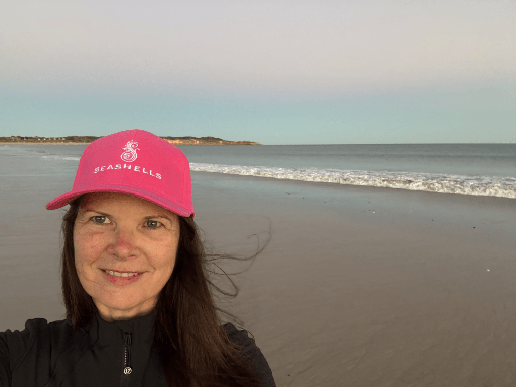 Carolyn Verhoef walking along a quiet beach at sunrise, enjoying restorative time in nature to support wellbeing and prevent ADHD burnout.