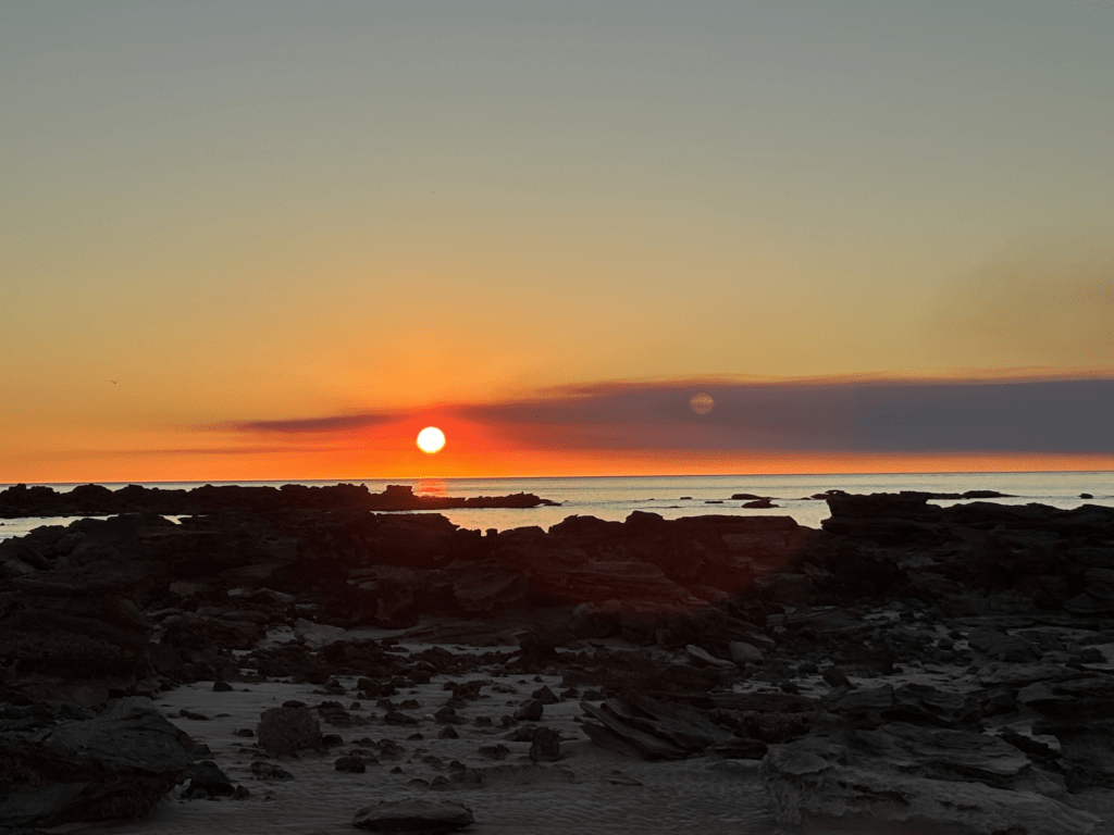 Golden sunset over the rugged Kimberley coastline, illustrating the calming effect of nature and intentional downtime.